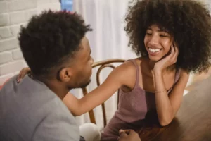 Couple noir assis à une table dans un appartement et discutant