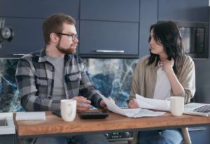 un couple assis a une table discute de manière constructive