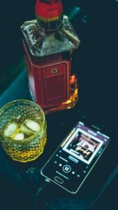 Un verre de whisky, une bouteille et un telephone